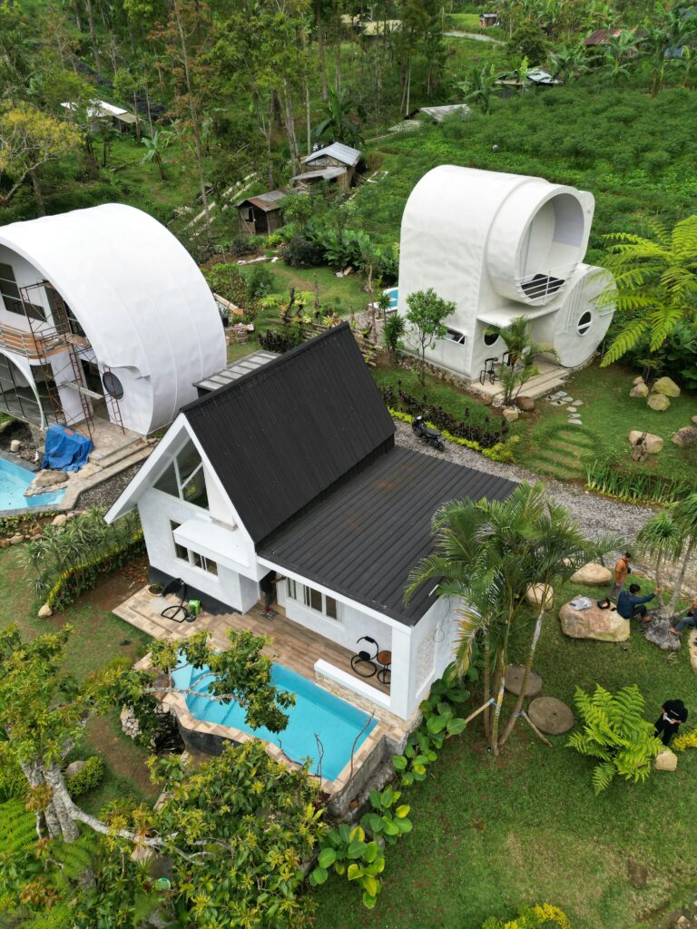 pexels-photo-33976161-33976161 Stunning aerial shot of two unique modern villas with pools, surrounded by lush greenery.