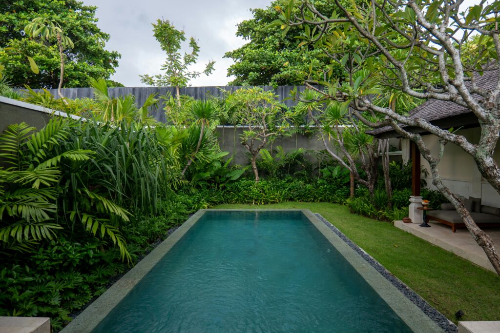 pexels-photo-36418268-36418268 Luxurious villa pool surrounded by lush tropical greenery in Bali, Indonesia.